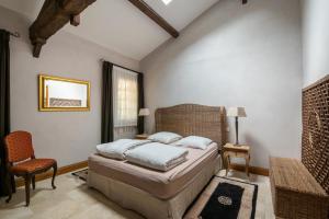 a bedroom with a bed and a chair and a window at Chateau de la Vieille Chapelle in Lugon et l’Ile du Carney