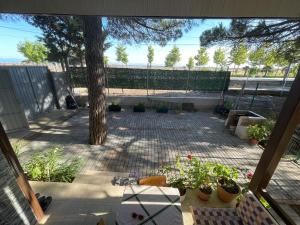 a patio with potted plants and a tree at Pinehouse Velipoja in Velipojë