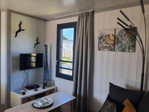 un salon avec une table et une fenêtre dans l'établissement Cottage 4-6 pers-piscine chauffée-150m plage, à Jullouville