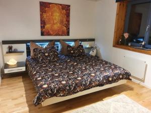 a bedroom with a large bed with a large painting on the wall at Kellergeschosswohnung mit Aussicht und Terasse in Strand