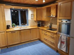 a kitchen with wooden cabinets and a sink at Kellergeschosswohnung mit Aussicht und Terasse in Strand