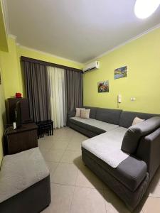 a living room with a couch and a tv at Bega Apartment in Sarandë