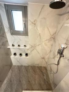 une salle de bain avec une douche et un lavabo et une fenêtre dans l'établissement Seva's House, à Rhodes
