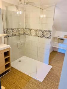 a shower with a glass door in a bathroom at Gîte Aubiacais 10 personnes in Aubiac