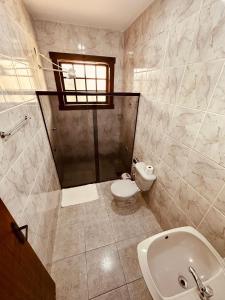 a bathroom with a shower and a toilet and a sink at Pousada Despertar de Minas in Tiradentes