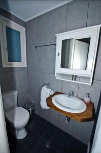a bathroom with a sink and a toilet and a mirror at MarKaMar in Loutraki