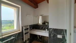 une salle de bain blanche avec un lavabo et une fenêtre dans l'établissement Agriturismo Mondomini, à Campofilone 53 autres photos
