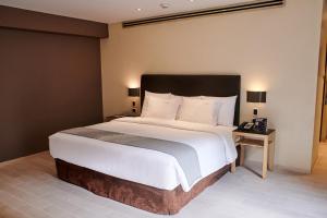 a bedroom with a large bed with white sheets and pillows at Casa Andina Premium Golf Los Incas in Lima