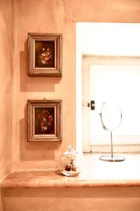 a room with a window with a mirror and a bowl of flowers at Il Convento in San Lorenzo Nuovo