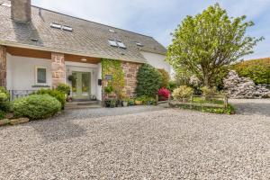a house with a gravel driveway in front of it at Heartseed House Bed & Breakfast in Dornoch