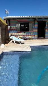 a swimming pool with a bench and a house at La Casita in Cuartillos