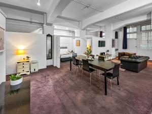 a living room with a table and chairs and a couch at Maison Marvel l Enormous Loft Apt l Heart of City in Auckland