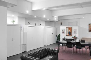 a room with a couch and a table and white cabinets at Maison Marvel l Enormous Loft Apt l Heart of City in Auckland
