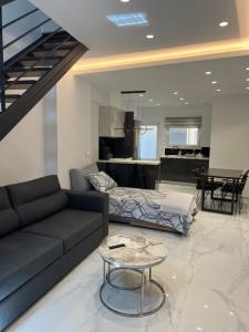 a living room with a couch and a table at OLGAS LoFT in Kavála