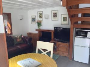 リングウッドにあるSelfcatering Coach House New Forest Dog Friendlyのソファとテレビのあるリビングルーム