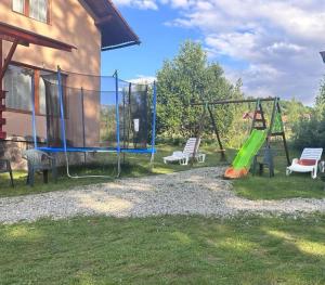a playground with two swings and two chairs at Casa "La padure" in Bran