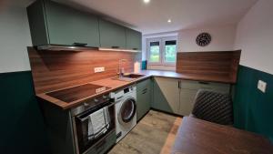 a kitchen with a sink and a washing machine at Pension am Schloss in Salzgitter