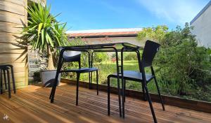two chairs and a table on a deck at Le P'tit Patio, Terrasse privative. in Lanester