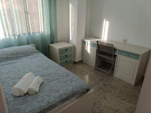 ein Schlafzimmer mit einem Bett, einem Schreibtisch und einem Computer in der Unterkunft Precioso piso cerca de la catedral in Almería