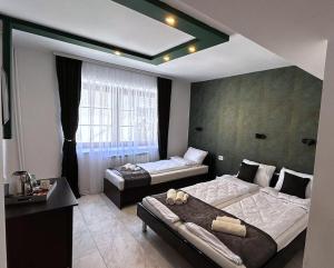 a bedroom with two beds and a large window at Villa Elena in Ohrid