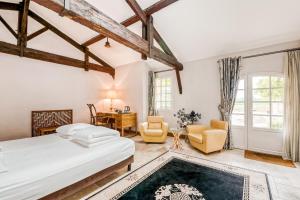 a bedroom with a bed and two chairs and a desk at Chateau de la Vieille Chapelle in Lugon et l’Ile du Carney