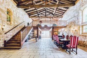 a dining room with a table and chairs and a staircase at Chateau de la Vieille Chapelle in Lugon et l’Ile du Carney