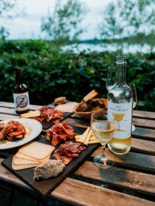 a bottle of wine and a plate of food on a wooden table at Chateau de la Vieille Chapelle in Lugon et l’Ile du Carney