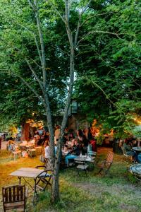 a group of people sitting at tables under a tree at Chateau de la Vieille Chapelle in Lugon et l’Ile du Carney