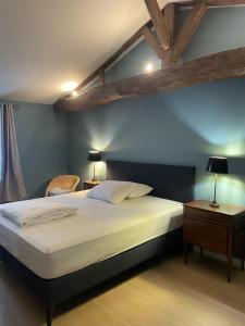 a bedroom with a large white bed with blue walls at Chateau de la Vieille Chapelle in Lugon et l’Ile du Carney