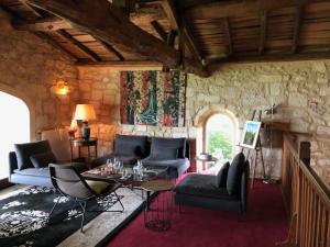 a living room with couches and a stone wall at Chateau de la Vieille Chapelle in Lugon et l’Ile du Carney