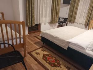 a bedroom with a bed and a crib and a chair at Casa "La padure" in Bran