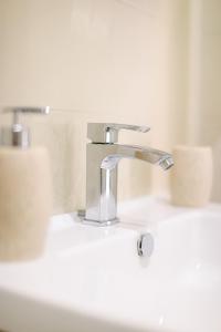 un lavandino del bagno con un rubinetto d'argento e due WC di DOMUS Gallery a Napoli