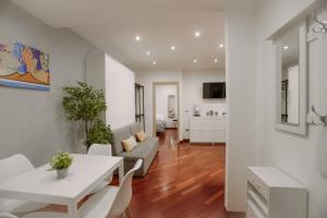 un soggiorno con tavolo e sedie bianchi di DOMUS Gallery a Napoli