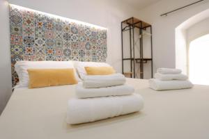 una camera da letto con due letti con asciugamani sopra di DOMUS Gallery a Napoli