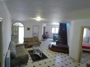 a living room with a couch and a table and stairs at Chalet con piscina Umut Homes in Alicante