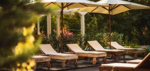 a row of lounge chairs and umbrellas on a patio at Тhe Cliff Obzor Bay and Holiday Apartments in Obzor