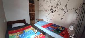 two twin beds in a room with a map on the wall at Cora Izone in Cob&aacute;n