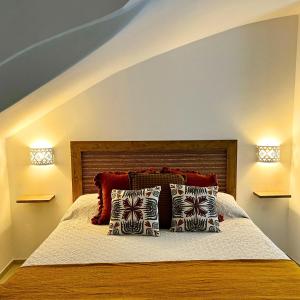 a bedroom with a bed with pillows and two lights at Casita in Santo Spirito