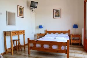 um quarto com uma cama e duas mesas e uma televisão em Seaview Studio Helen No 2 em Xiropigado