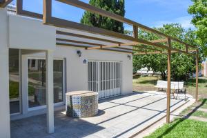 a pergola over a patio with a bench at CASA Del RODEO in General Ramírez