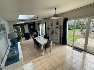 una cucina e una sala da pranzo con tavolo e sedie di Domaine entier Le Clos des Trois Provinces 20 personnes Zoo Beauval a Noyers-sur-Cher
