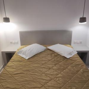 a bed with two pillows on top of it at Il Margio Studio in Tinos Town