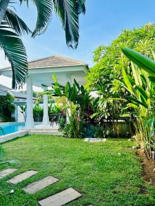 a house with a garden and a swimming pool at Samui Sunset 22G in Choeng Mon Beach