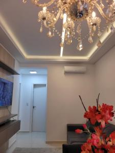 ein Wohnzimmer mit einem Kronleuchter an der Decke in der Unterkunft Apartamento Residencial Mar Azul - praia de Palmas - Governador Celso Ramos-SC in Governador Celso Ramos + 28 Fotos