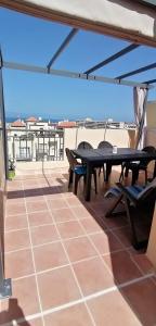 a patio with a table and chairs on a roof at Chilly Apartment - Sunny rooftop terrace with ocean view in Callao Salvaje
