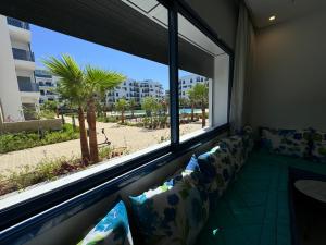 a living room with a couch and a large window at Playa 7 in Martil
