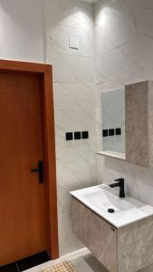a bathroom with a sink and a mirror at شقة فندقيه Happy Season in Hajlah