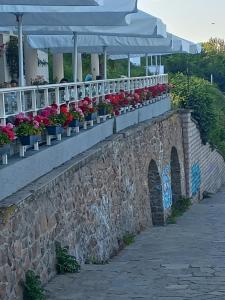 a stone wall with flowers inpots on it at Apartment Krisiya in Burgas in Burgas City