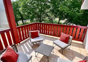 a porch with two chairs and a table and two chairs at Pins & Lacs in Biscarrosse
