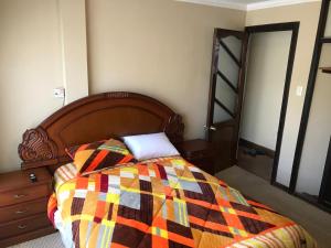 a bedroom with a bed with a colorful blanket at C14 de Obrajes in La Paz +2 photos